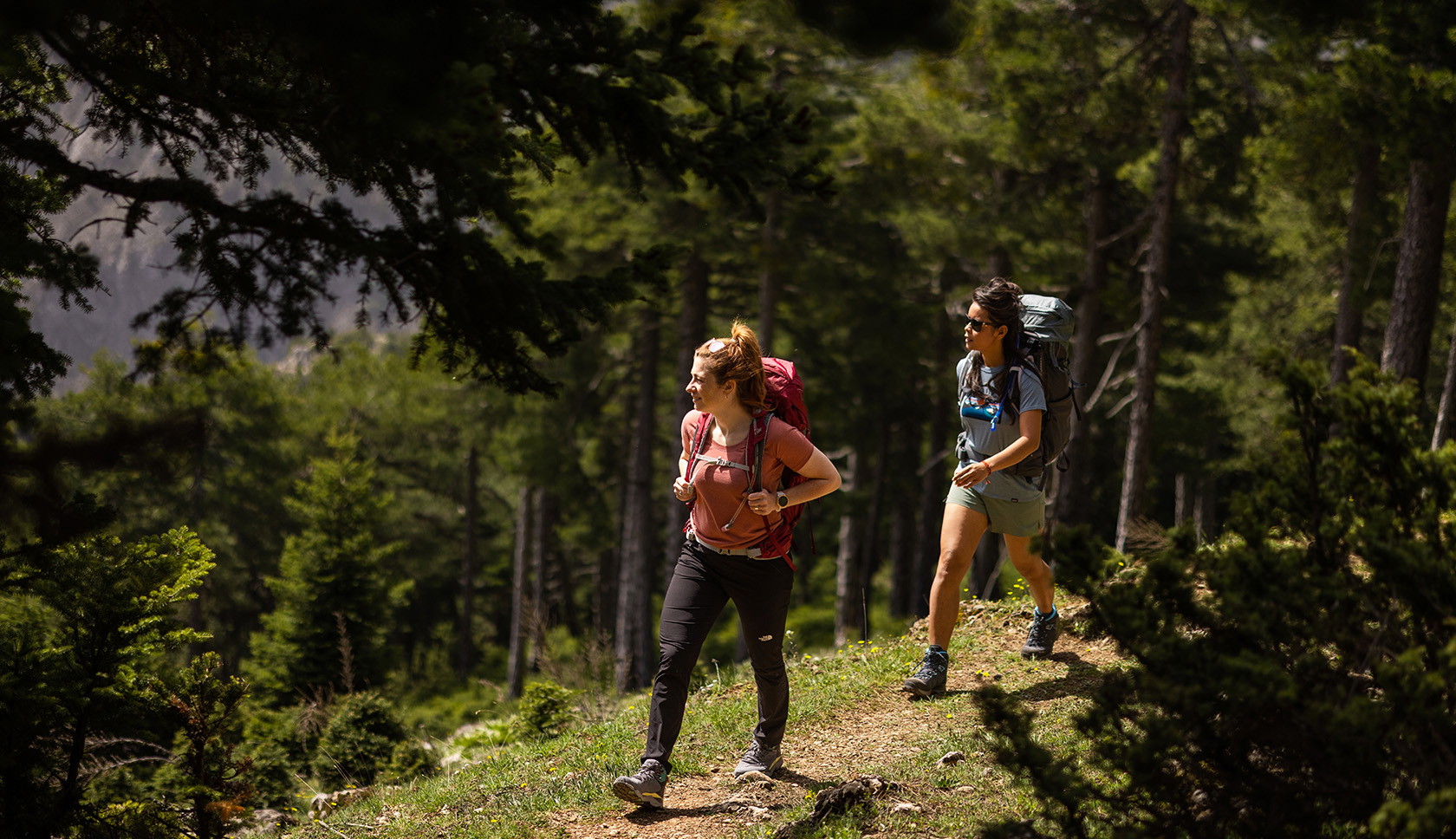 twee vrouwen lopen door bergen met merino wollen kleding