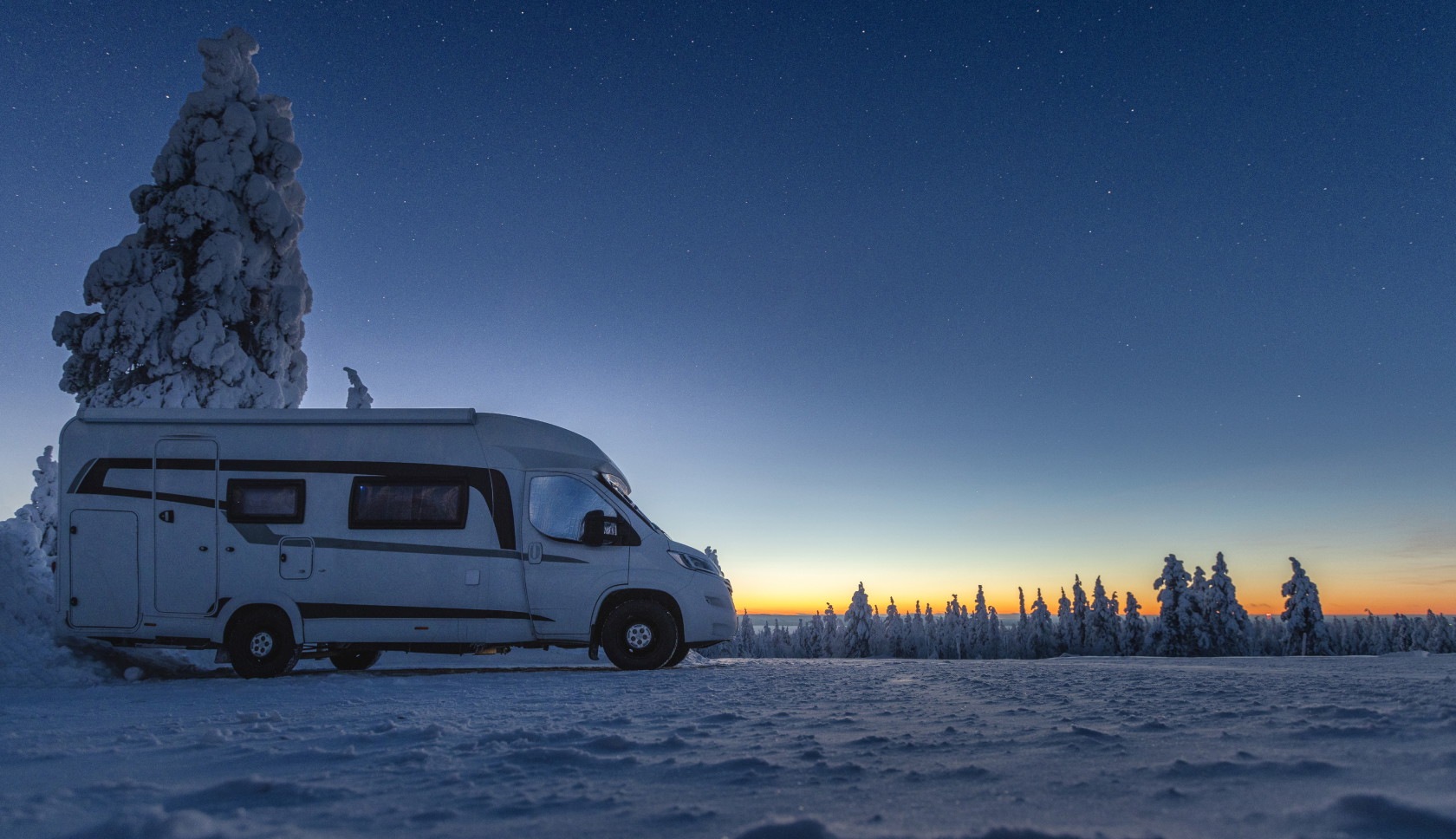 caravan rijdt door besneeuwd gebied