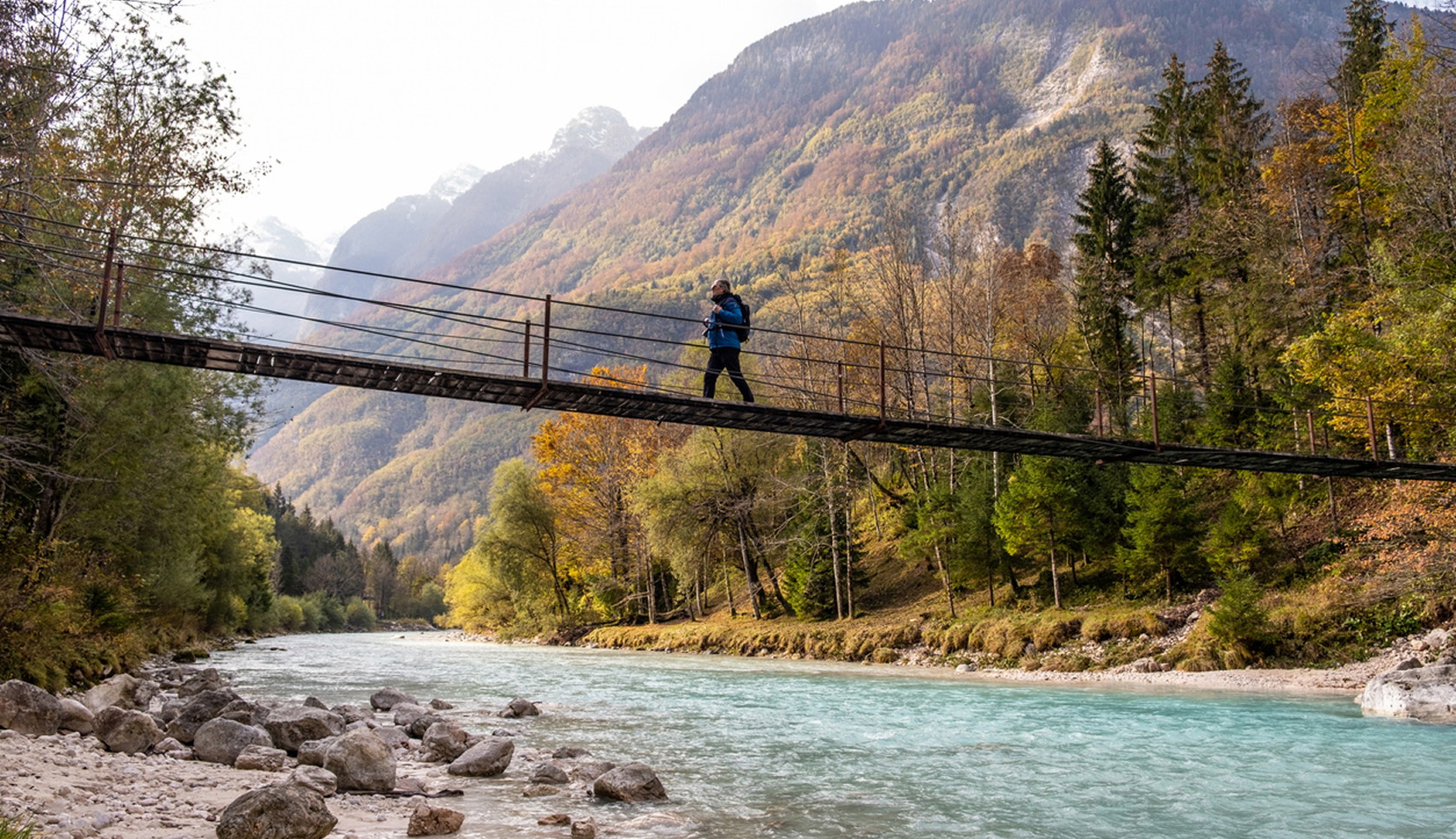 Wandelaar op een hangbrug boven de Soča-rivier bij Kobarid in Slovenië