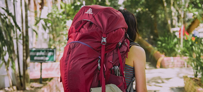 vrouw met rode backpack op haar rug