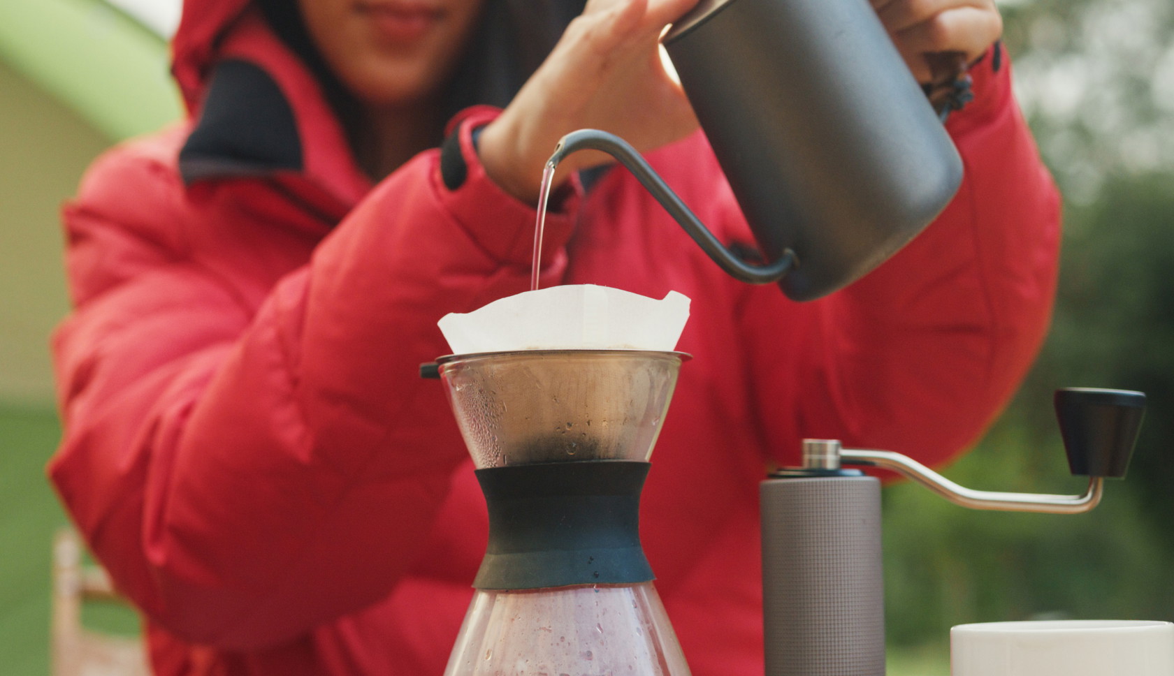 vrouw schenkt heet water in een dripper