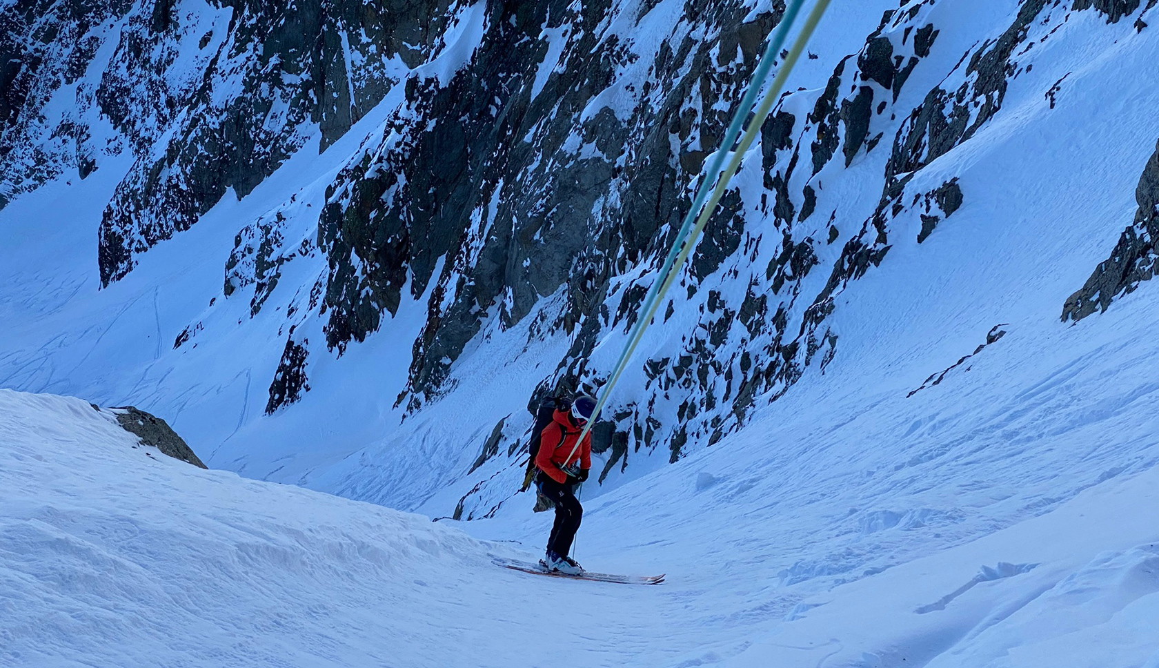 tourskier abseilt in een besneeuwd dal