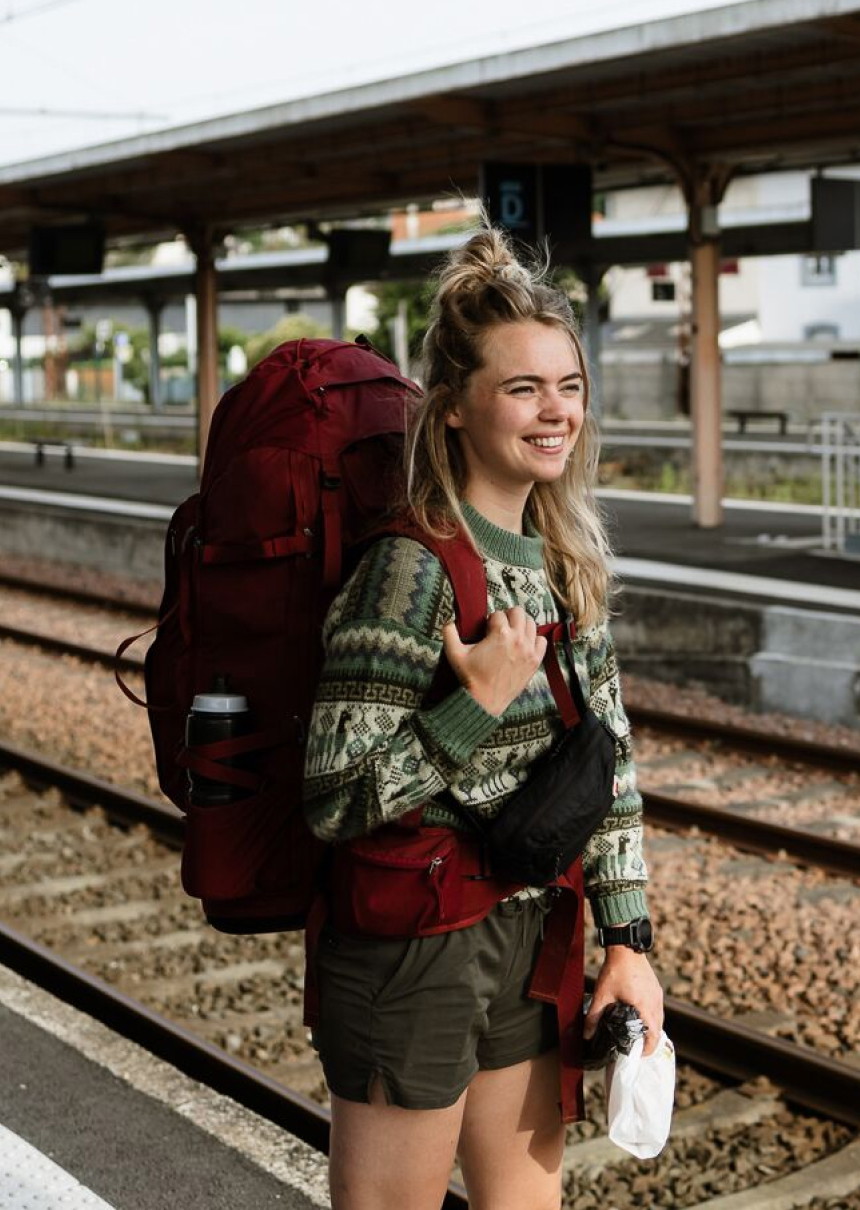 vrouw met backpack staat op treinstation