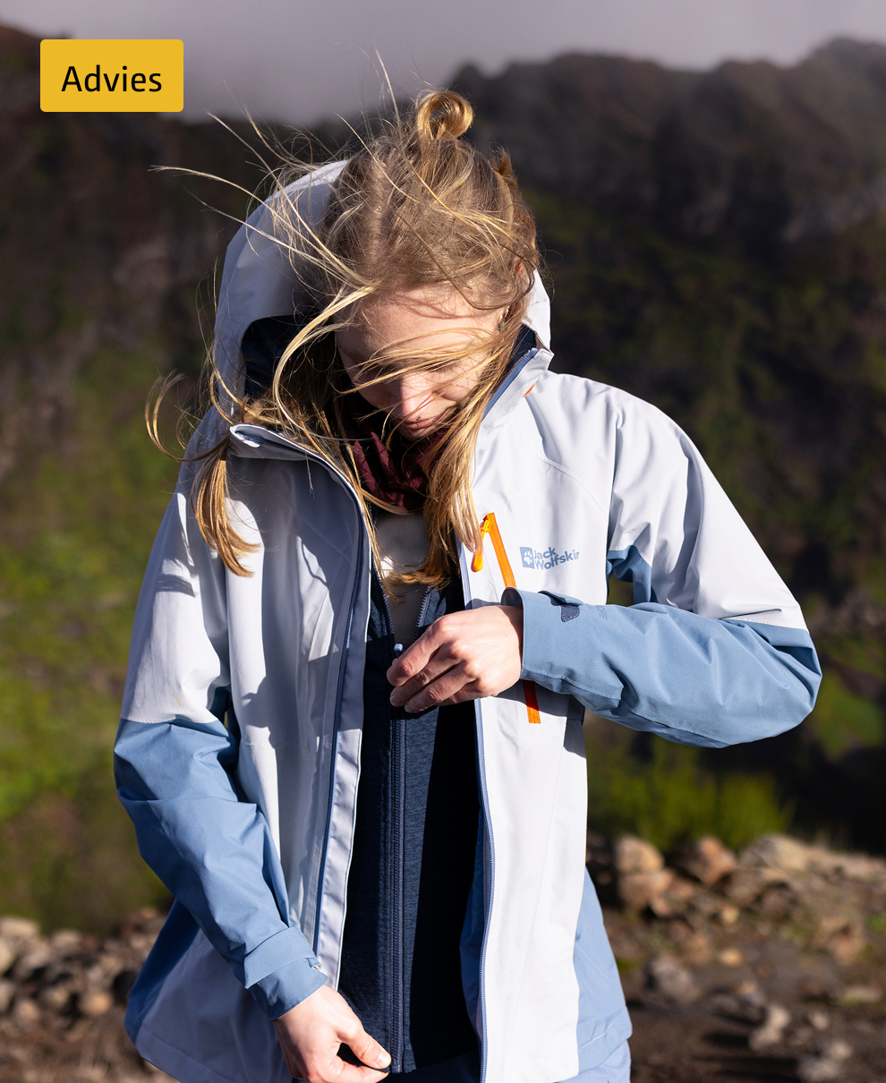 vrouw ritst haar vest dicht onder hardshell