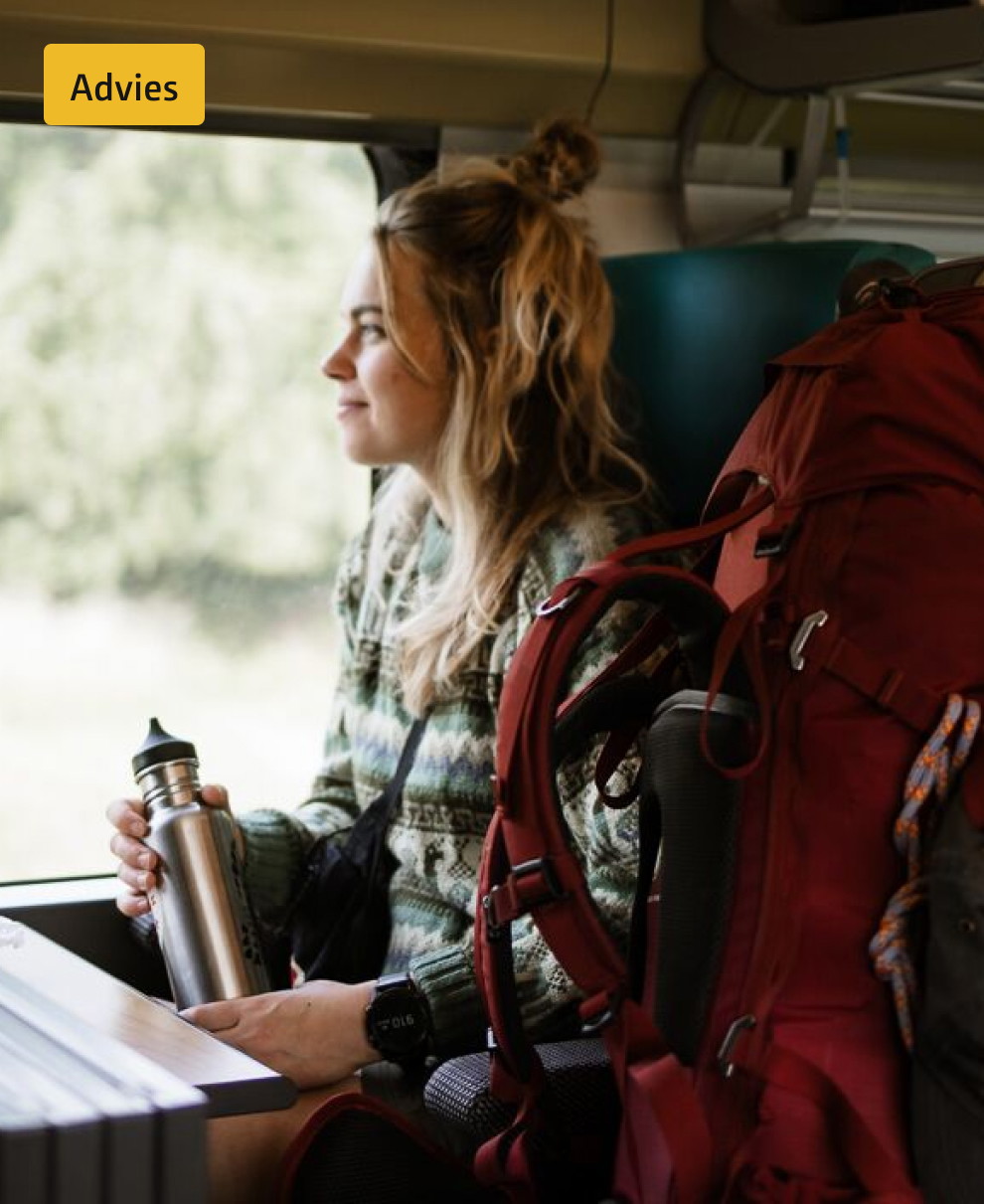 vrouw zit naar backpack in de trein