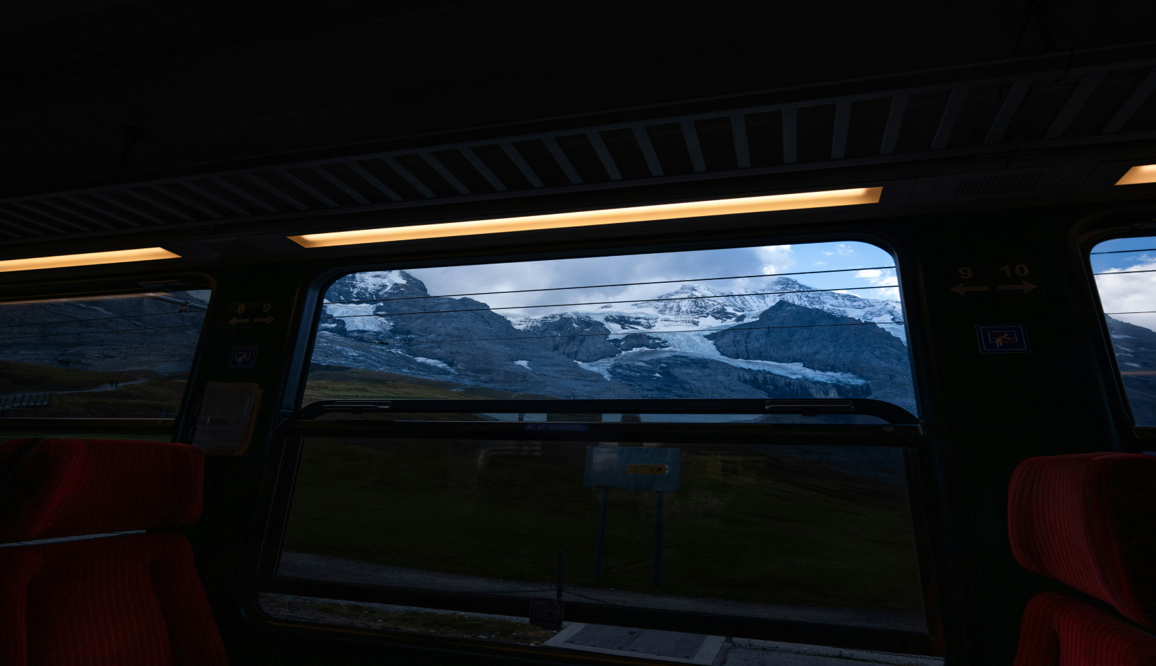 Zicht op de bergen vanuit een donkere trein.