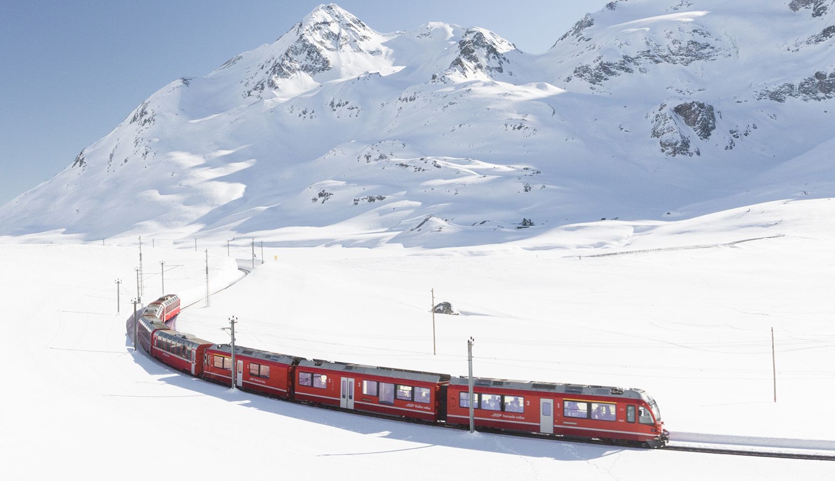 Rode rijdt over een besneeuwd treinspoort door de bergen.