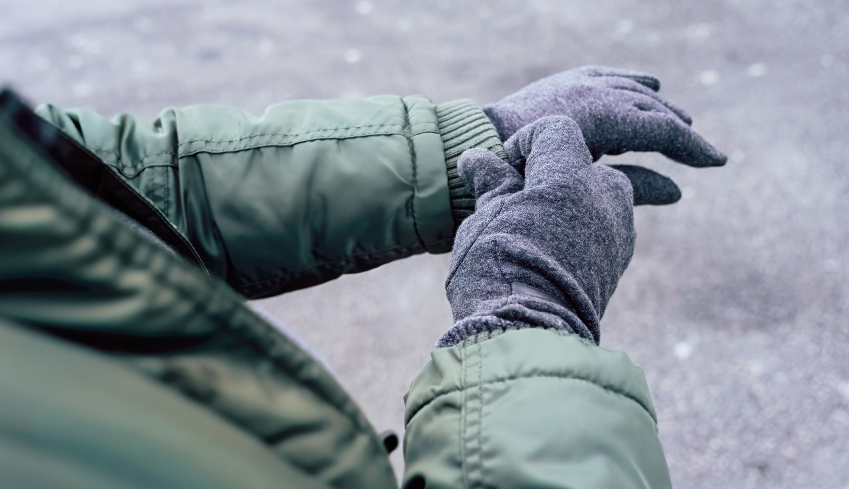man met gele regenjas en waterdichte handschoenen voelt voor regen in de bergen