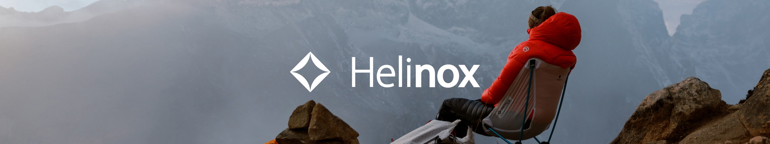 man zit op een Helinox stoeltje hoog in de bergen