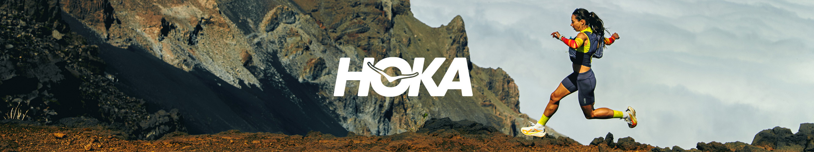 Trailrunner met HOKA hardloopschoenen in een ruig berglandschap
