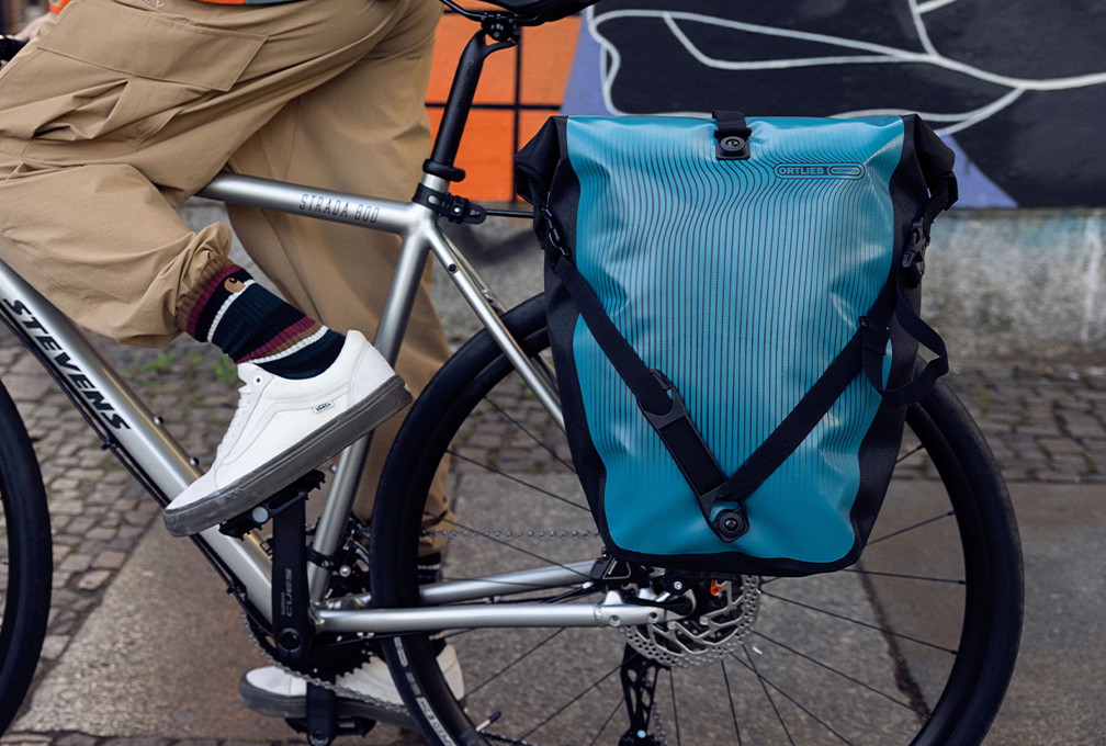 Blauwe Ortlieb fietstas aan de bagagedrager van een fiets